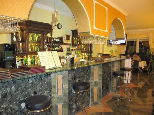 eine Bar in einem Restaurant mit Hockern in der Unterkunft Hotel Colosseum in Olecko