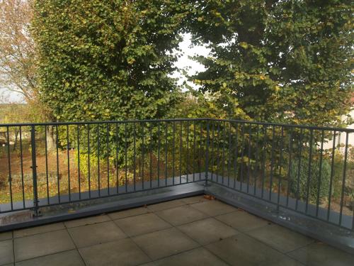 a balcony with a fence and a tree at LES JARDINS DE LA GRANGE in Rezonville