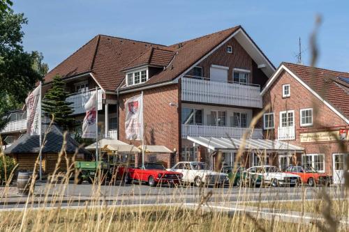 een gebouw waar auto's voor geparkeerd staan bij Frommanns Landhotel in Buchholz in der Nordheide