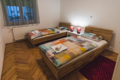 2 camas en una habitación con 2 velas rojas en Apartments "Pavić" near Zagreb Airport, en Velika Gorica