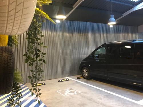 een zwart busje geparkeerd in een garage met een plant bij Plaza 5 Carabanchel Apartment in Madrid