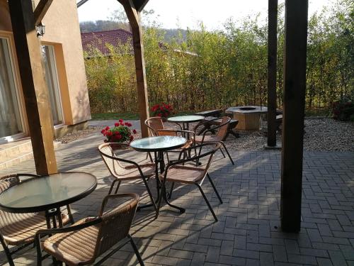 - un ensemble de tables et de chaises sur une terrasse dans l'établissement Felsőréti Vendégház, à Demjén