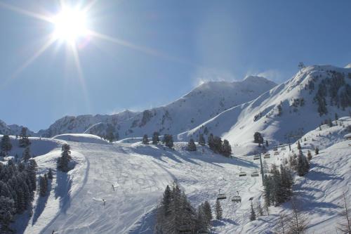 a snow covered mountain with the sun in the sky at Gasthof Burkert in Oetz