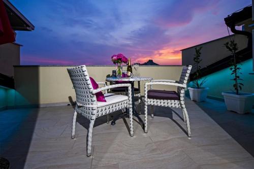 two white chairs and a table on a balcony at Apartments Babo in Rovinj