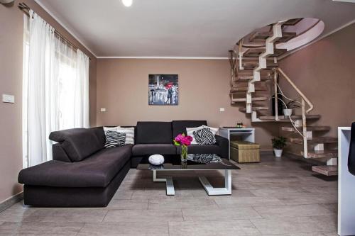 a living room with a couch and a staircase at Apartments Babo in Rovinj