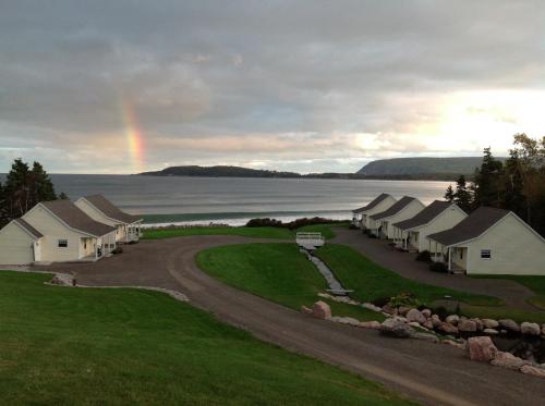 een regenboog in de lucht boven een rij huizen bij Lantern Hill & Hollow in Ingonish Beach