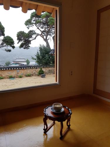 een tafel in een kamer met een groot raam bij Jukheon Traditional House in Andong