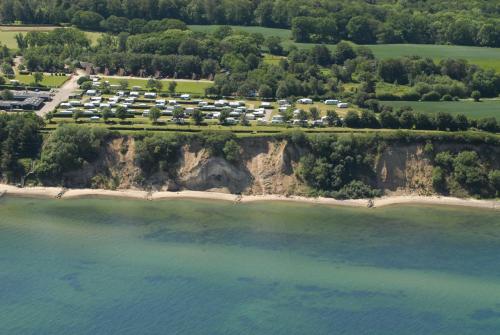 una vista aerea di un resort su un'isola rocciosa in acqua di Dancamps Trelde Naes (Camp Site) a Fredericia