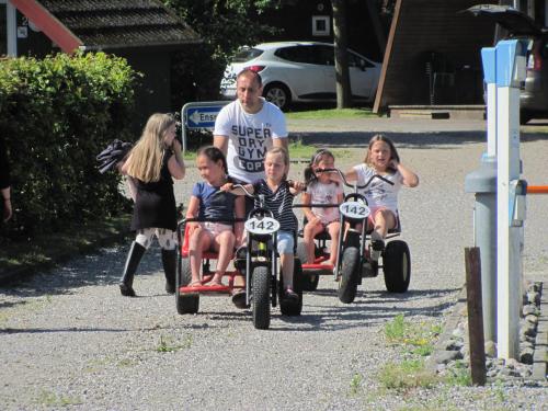 un gruppo di bambini che cavalca su tricicli lungo una strada di Dancamps Trelde Naes (Camp Site) a Fredericia