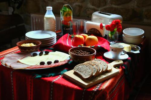 ein Tisch mit Brot und anderen Lebensmitteln darauf in der Unterkunft Melnik Pyramids Guesthouse in Zlatkov Chiflik