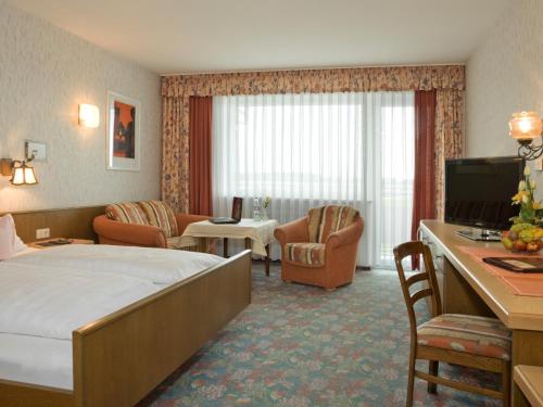 ein Hotelzimmer mit einem Bett und einem Wohnzimmer in der Unterkunft Hotel Pension Fent in Bad Füssing