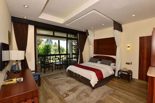 una camera con letto e balcone di Baobab Holiday Resort a Bamburi