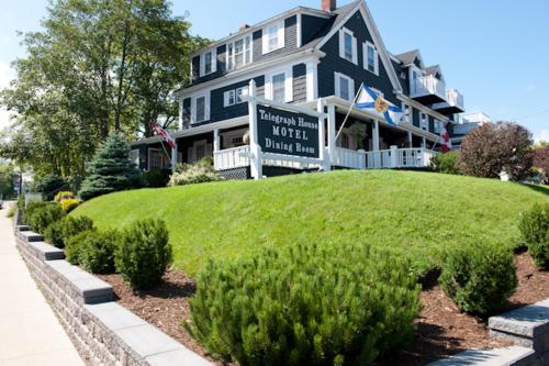 a large house with a sign in front of it at Telegraph House Motel in Baddeck