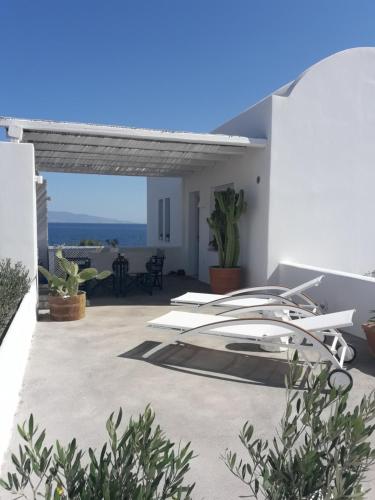 een patio met een surfplank aan de zijkant van een huis bij Sun Anemos Resort in Oia