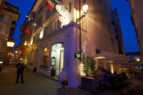 a building with a clock on the side of it at Boutique Hotel Weisses Kreuz - Adult only Hotel in Luzern