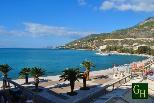 - une vue sur la plage bordée de palmiers et l'océan dans l'établissement Grand Hotel Loutraki, à Loutraki