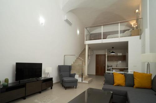 uma sala de estar com um sofá e uma televisão em Apartamento Turístico Centro Monumental -- Caceres em Cáceres