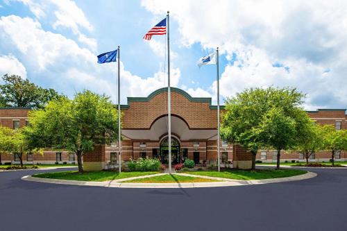 Due bandiere americane volano davanti a un edificio di mattoni di Comfort Inn Indianapolis North - Carmel a Carmel