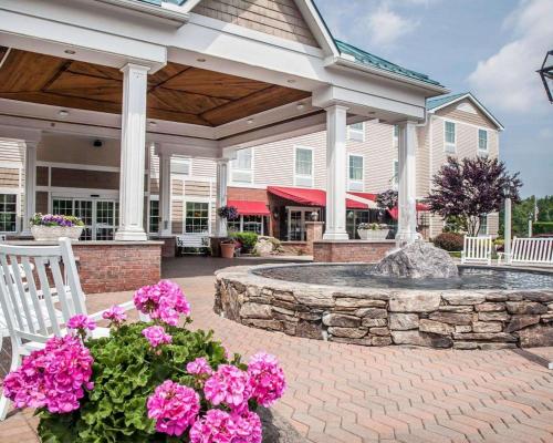 dom z kamiennym patio z kwiatami i fontanną w obiekcie Comfort Inn & Suites Sturbridge-Brimfield w mieście Sturbridge