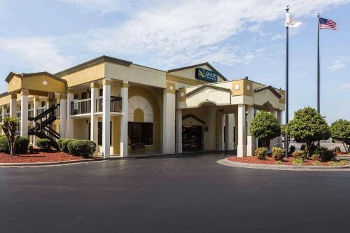 a hotel building with a flag in a parking lot at Quality Inn & Suites Mooresville-Lake Norman in Mooresville