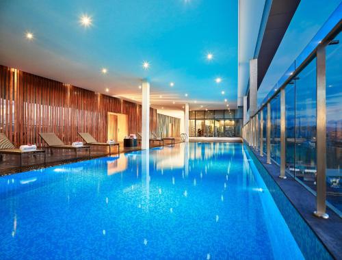 una gran piscina de agua azul en un edificio en Vivanta Pune, Hinjawadi, en Pune