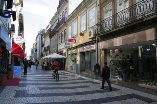 una persona que va en bicicleta por una calle en una ciudad en Hotel Estoril Porto, en Oporto