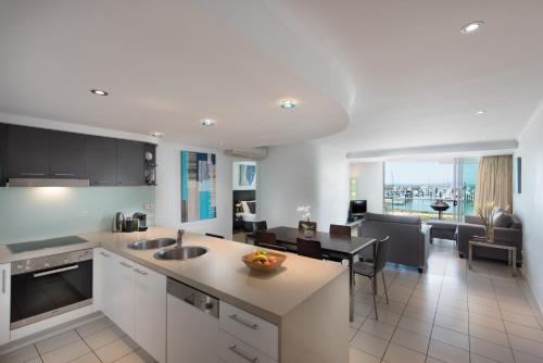 a kitchen and living room with a table and a kitchen and a dining room at at Marina Shores in Airlie Beach