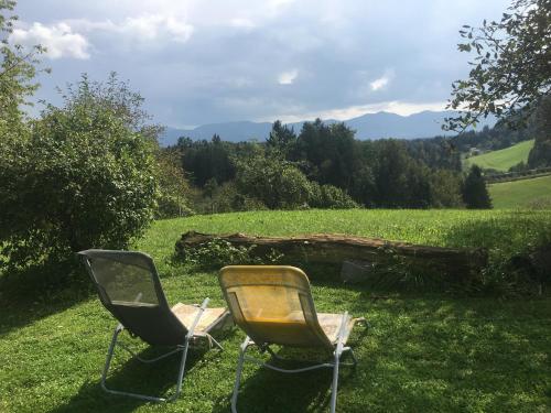 due sedie sedute nell'erba in un campo di Blue Cottage a Podvrh