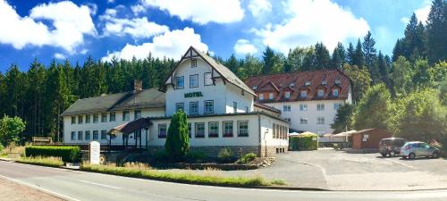 duży biały budynek przy drodze w obiekcie Hotel Rodebachmühle w mieście Georgenthal