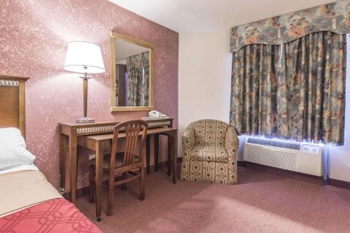 a hotel room with a desk and a chair at Econo Lodge in Orillia