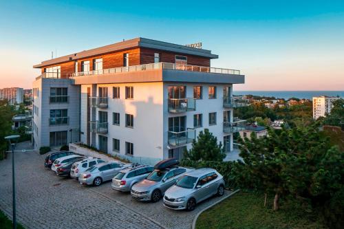 un bâtiment avec des voitures garées dans un parking dans l'établissement Sea Premium Apartments - Destigo Hotels, à Gdynia