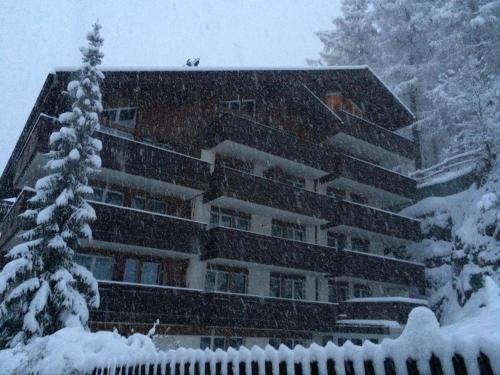 budynek pokryty śniegiem z przodu w obiekcie Bolero Appartements w mieście Zermatt