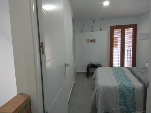 um quarto com uma cama e uma porta para um quarto em Caleros 8 Apartamento - Apartamentos de la Parte Antigua de Cáceres em Cáceres