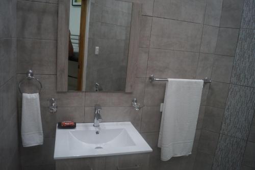 y baño con lavabo, espejo y toallas. en City Caribbean Hotel Boutique, en Santo Domingo