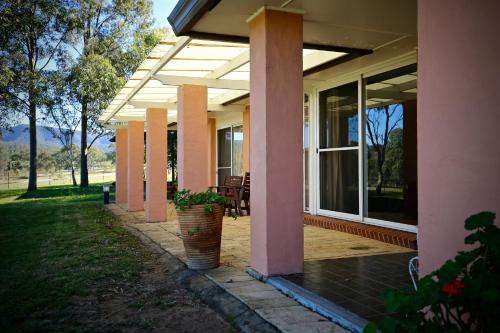 a porch of a house with a patio at Verona Vineyard Cottage in Pokolbin