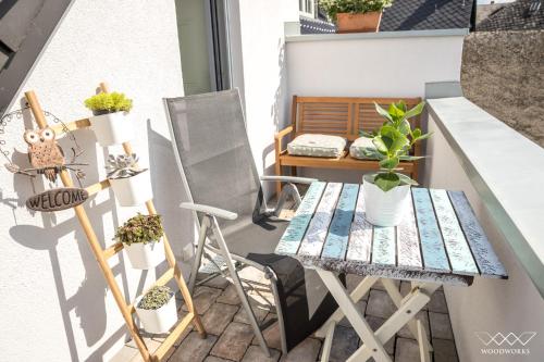 un piccolo balcone con tavolo e piante in vaso di TeigenHeim a Rüdesheim am Rhein