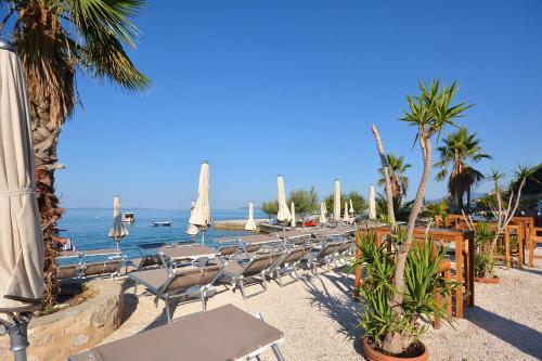 - une plage avec des chaises et des parasols et l'océan dans l'établissement Hotel Jona, à Podstrana