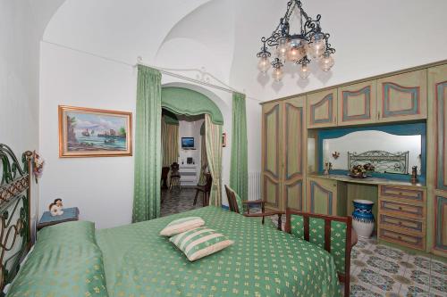 ein Schlafzimmer mit einem grünen Bett und einem Kronleuchter in der Unterkunft Casa Teresa in Positano