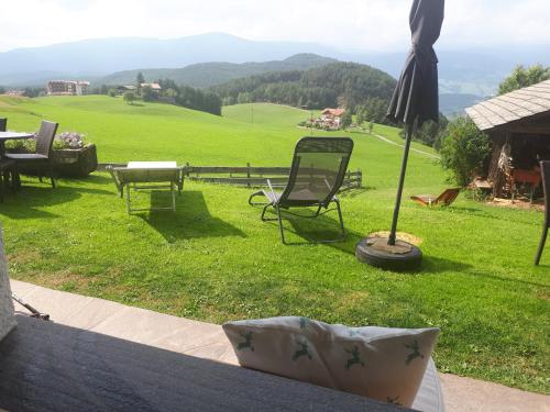 a view of a lawn with a table and an umbrella at Kompatscherhof in Castelrotto