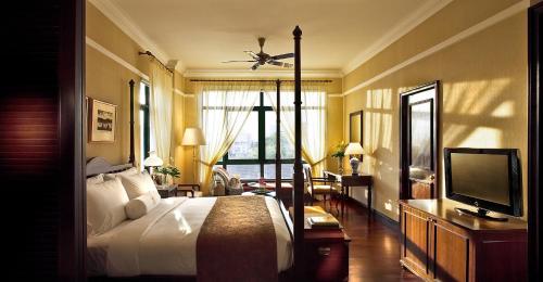 a hotel room with a bed and a television at The Majestic Malacca Hotel - Small Luxury Hotels of the World in Melaka