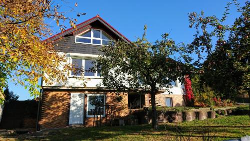 een huis met een boom ervoor bij Ferienhaus am Rehberg in Eisenach