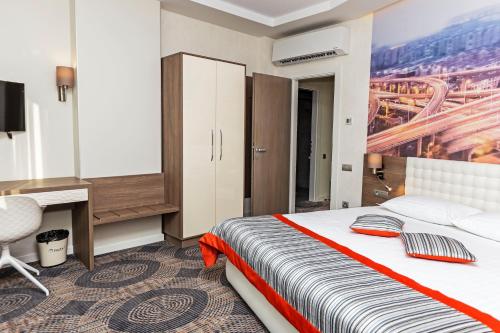 a bedroom with a bed and a desk and a computer at Plaza35 in Sibiu