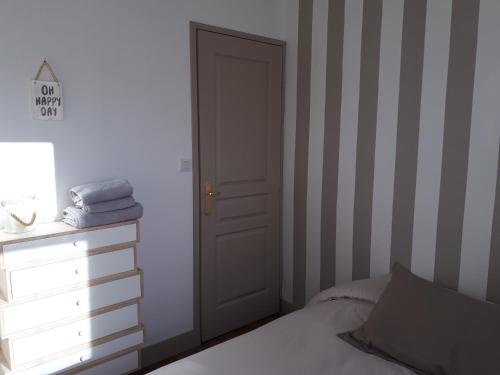 1 dormitorio con puerta, 1 cama y vestidor en Un Appart en Ville, en Niort