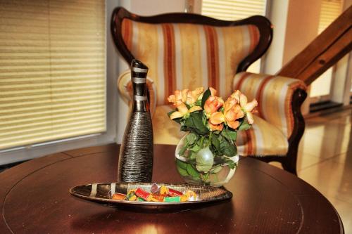 une table avec un vase de fleurs et une assiette de nourriture dans l'établissement Oppenheimstrasse 2, à Eisenach