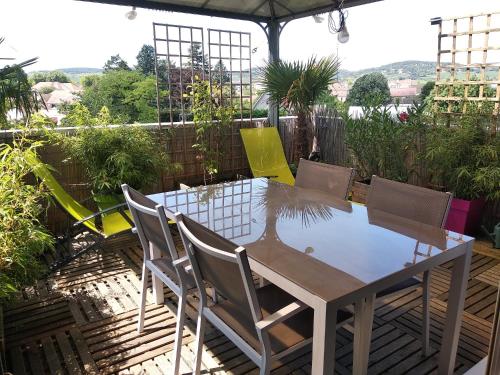 einen Tisch und Stühle auf einer Terrasse in der Unterkunft Datcha Bourguignonne Beaune in Beaune