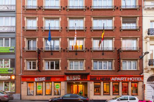 een groot gebouw van rode baksteen met vlaggen voor het gebouw bij Wellness Apart Hotel in Brussel