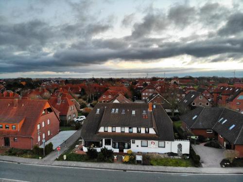 a large house in a residential neighborhood with houses at Hotel Carolinensiel Doan in Carolinensiel