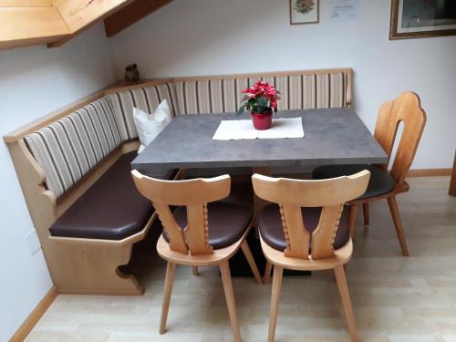 a table with two chairs and a vase of flowers on it at Apartment Suliva in Santa Cristina in Val Gardena