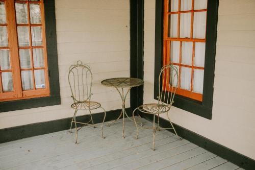 2 Stühle und ein Tisch auf einer Veranda in der Unterkunft Maison Mouton Bed & Breakfast in Lafayette