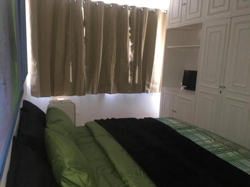 1 dormitorio con 1 cama en una habitación con ventana en Adonai Copacabana Rooms 01, en Río de Janeiro